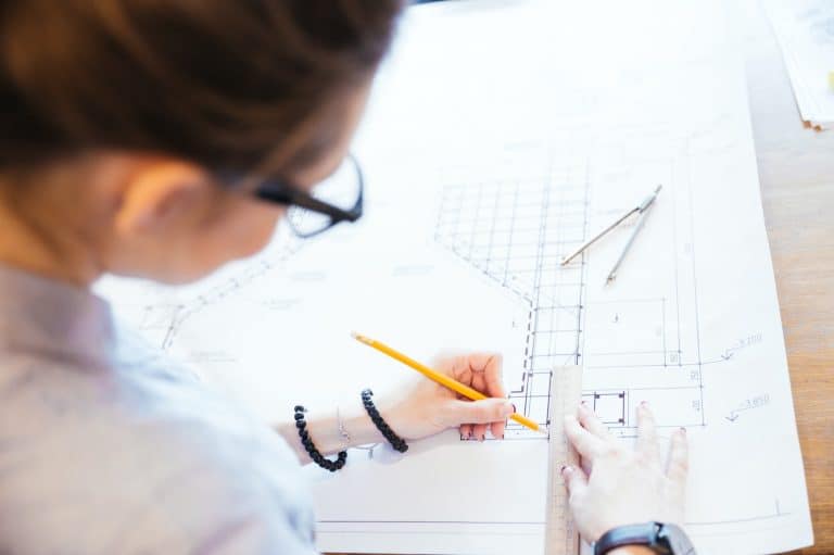 Woman engineer working on blueprint person