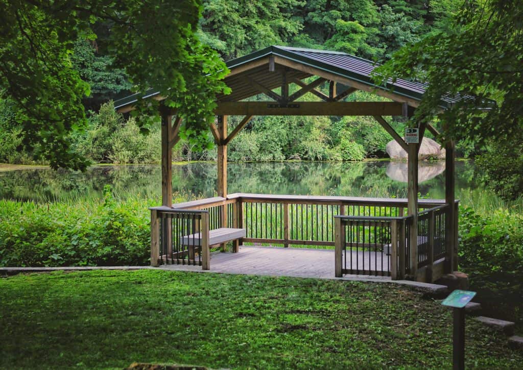 gazebo over deck in grass and water wood railing