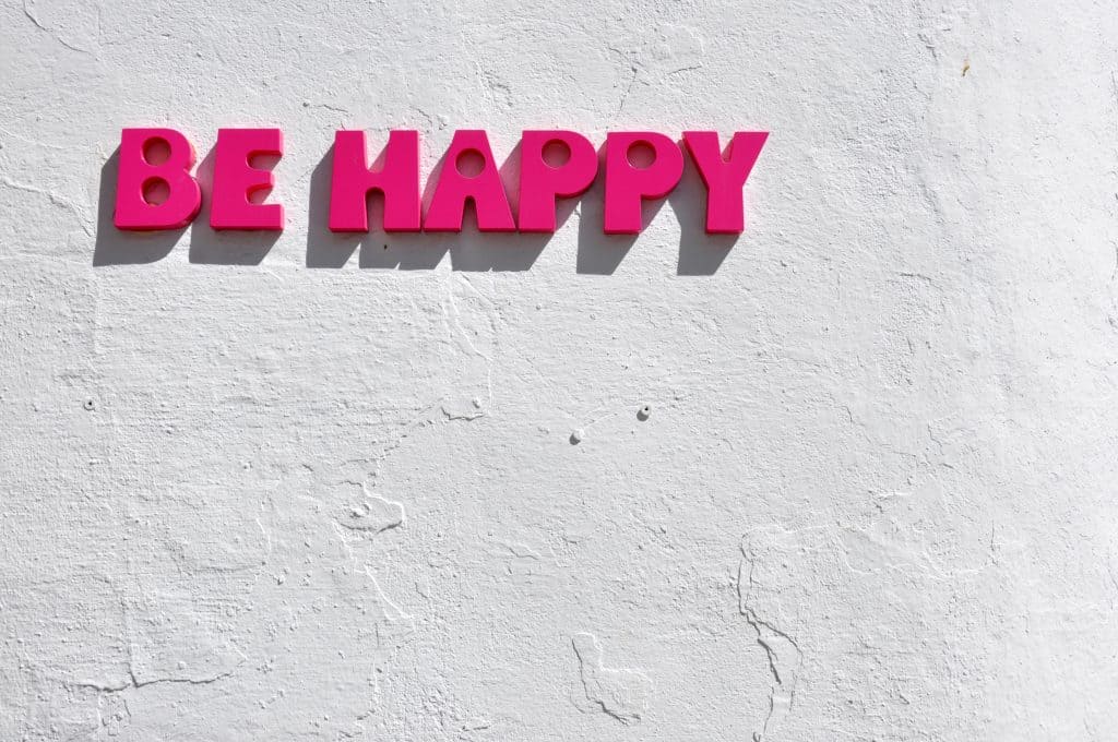 be happy sign on white wall