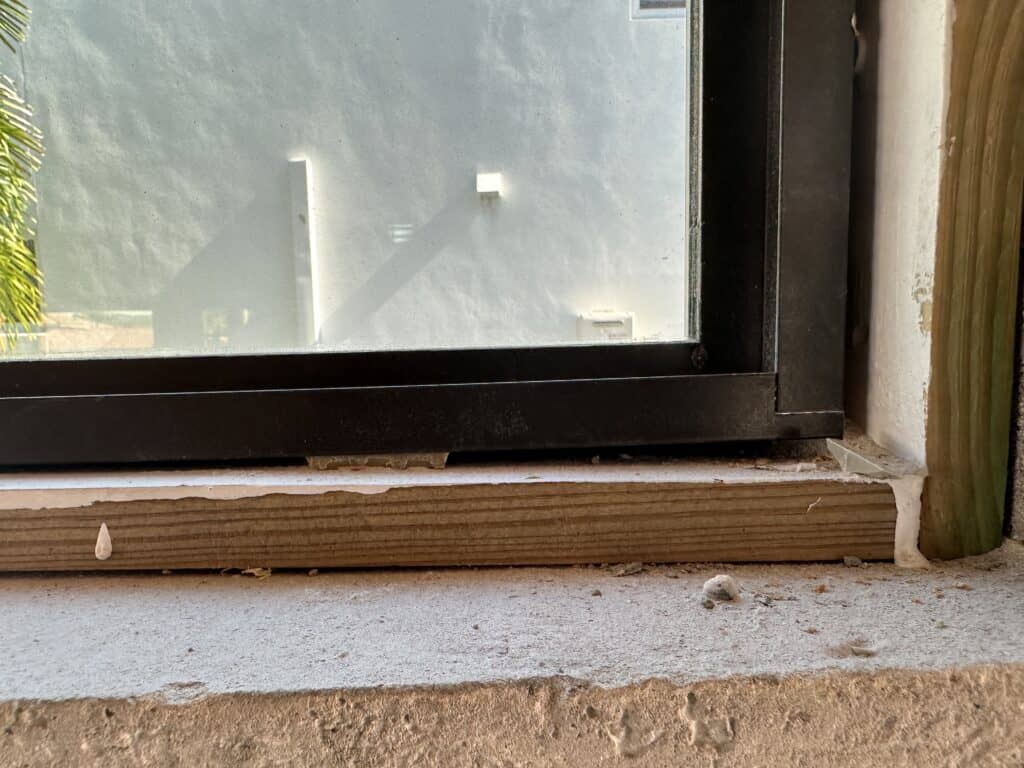 Installed window with plastic shims to level