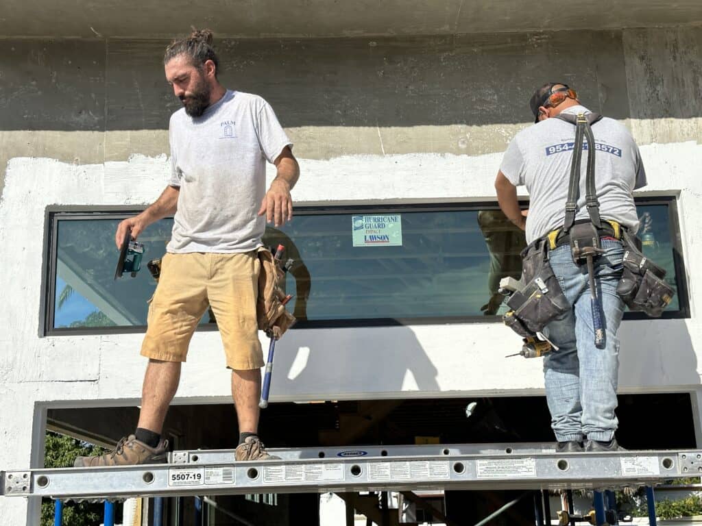 Javier and Billy installing a window